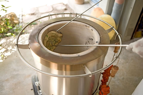 naan cooking in a tandoor oven